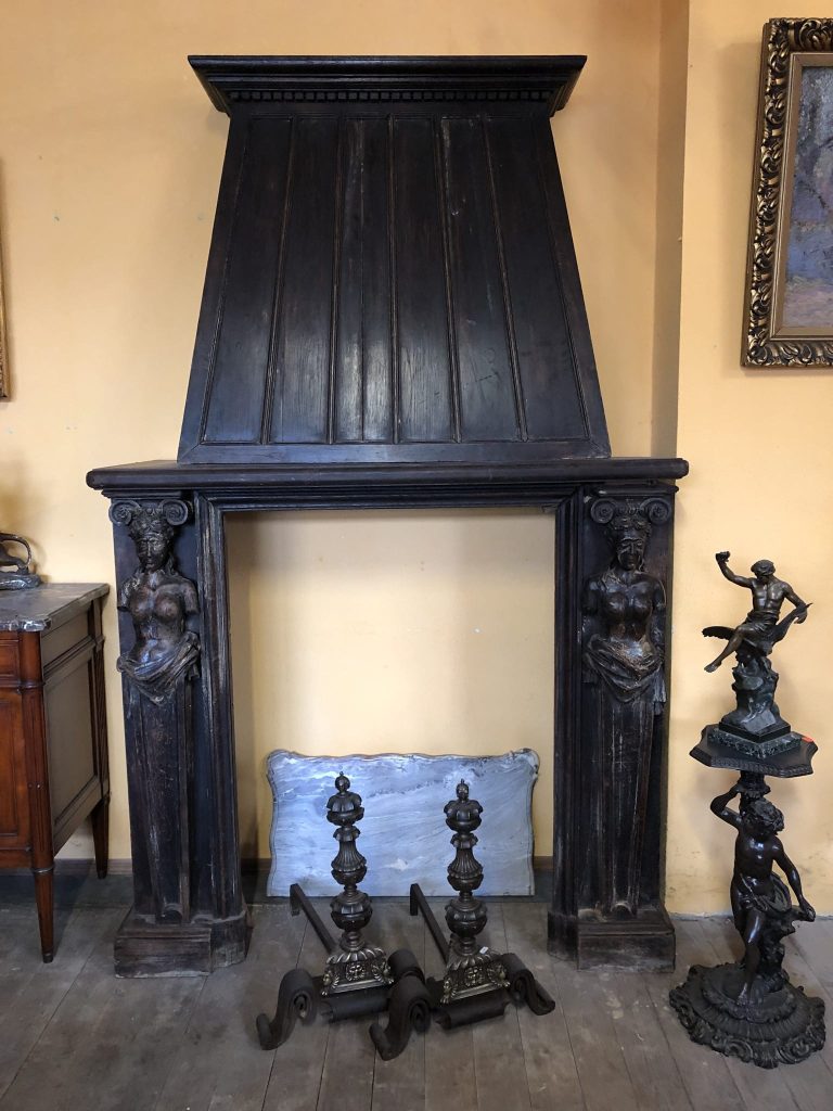 Antique carved fireplace in oak with caryatid figures and chimney hood