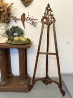 Antique French Neorococo carved wood studio display easel with ornate openwork rocaille cresting and acanthus leaf details on sweeping cabriole legs.