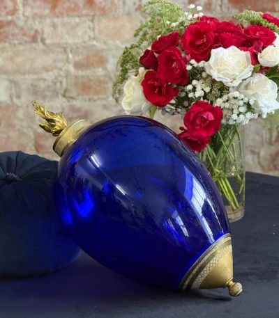 Beautiful dark blue glass decor with ornate bronze mounts and a sculptural flame finial in Empire style.