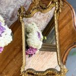 Gilt rococo wall mirror with ribbon bow crest