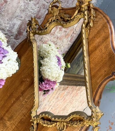 Gilt rococo wall mirror with ribbon bow crest