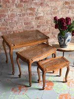antique wooden nesting tables with caned glass tops set of three