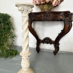 White cast stone pedestal column with spiral twist shaft and Corinthian acanthus capital