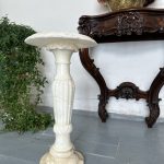 Carved alabaster pedestal column with fluted baluster shaft and leaf-carved top
