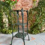 Dark green cast iron plant stand etagere with three pierced tiers and paw feet