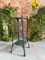 Dark green cast iron plant stand etagere with three pierced tiers and paw feet