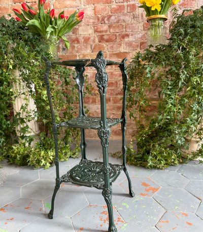 Dark green cast iron plant stand etagere with three pierced tiers and paw feet