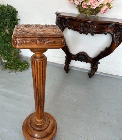 Carved walnut pedestal column with fluted shaft and foliate-carved square top