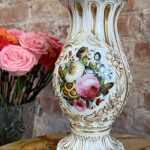 Ornate French porcelain vase with hand-painted floral bouquets and gold relief detailing