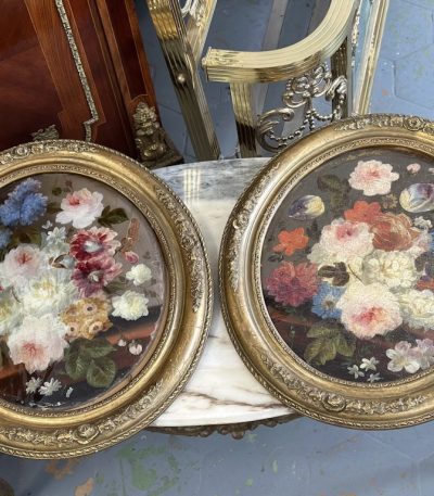 pair of antique oval floral oil paintings under glass in ornate gilt frames