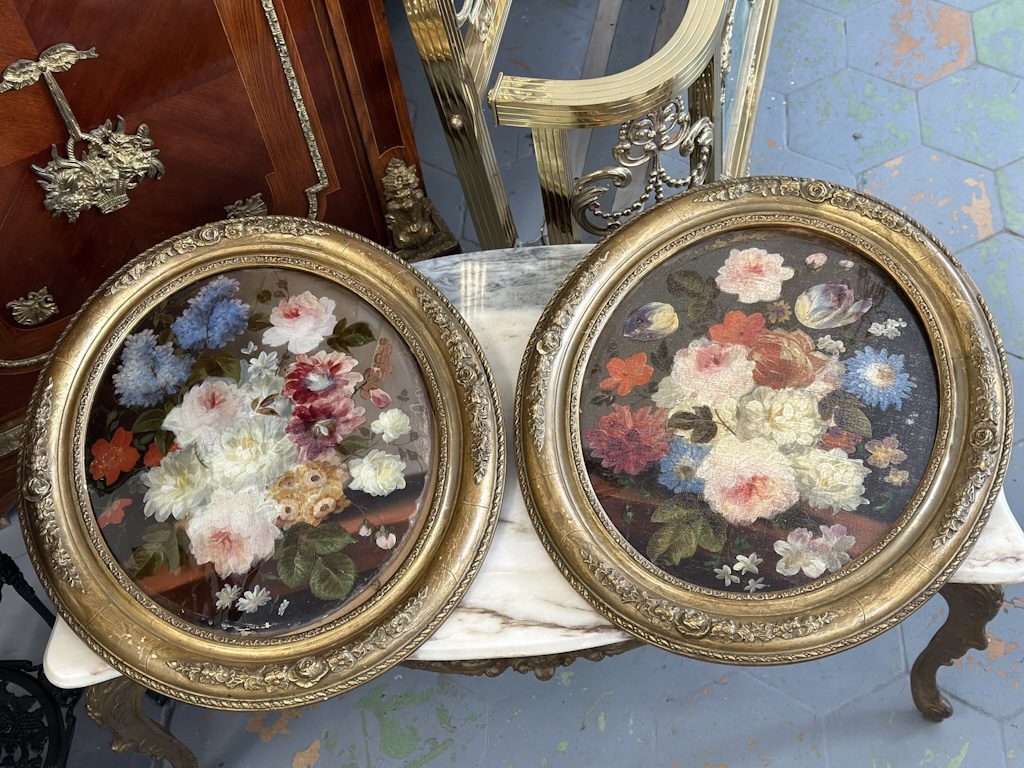 pair of antique oval floral oil paintings under glass in ornate gilt frames