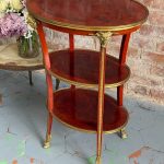 Antique Louis XVI style mahogany three-tier side table with bronze ram heads