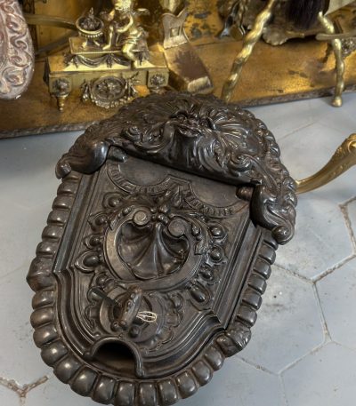 Antique cast iron coalbox with grotesque mask and shell relief
