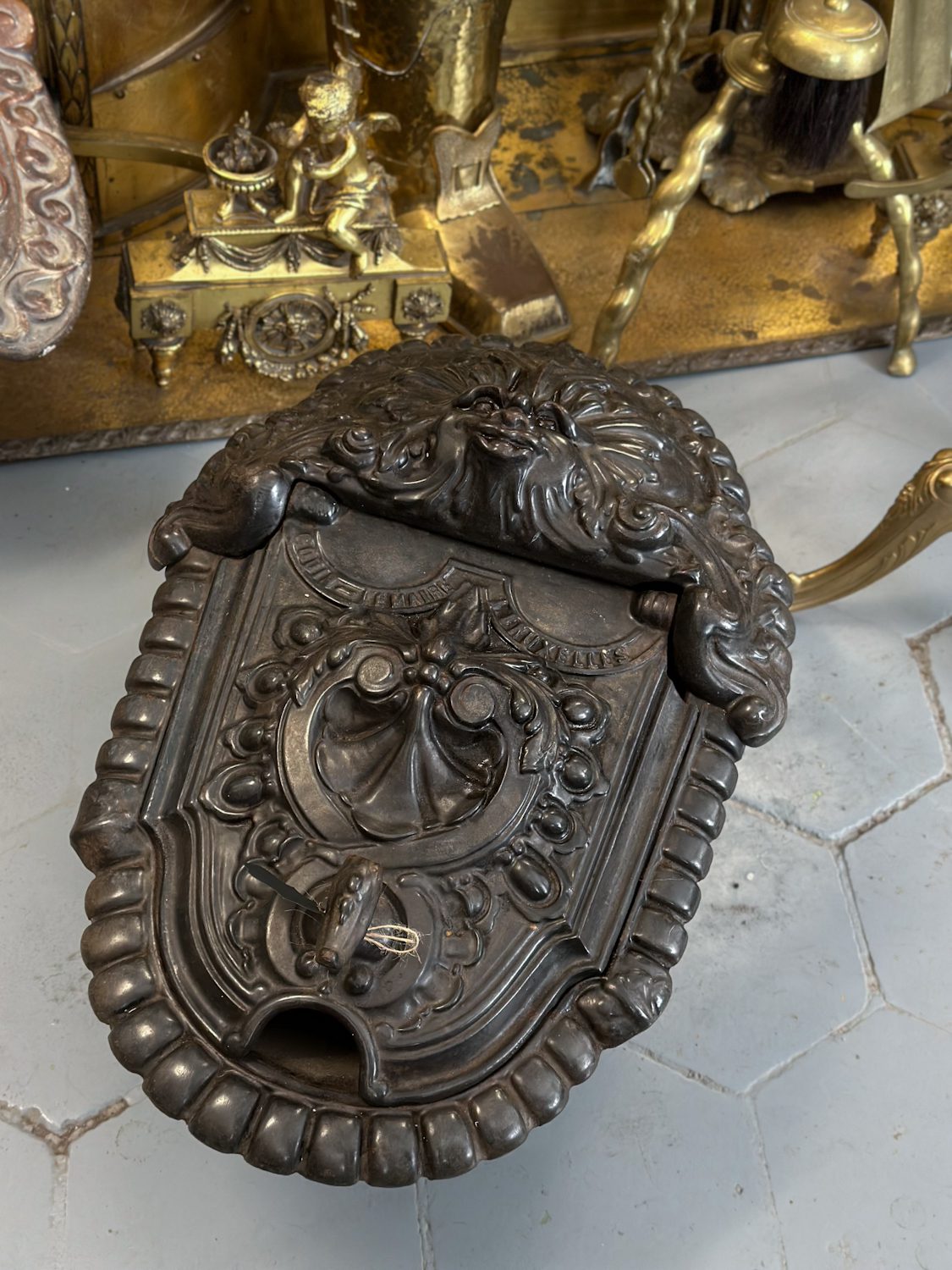 Antique cast iron coalbox with grotesque mask and shell relief