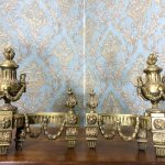 Pair of antique gilt-bronze Louis XVI chenets with flaming urns and laurel garlands