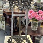 Antique Renaissance Revival metal display easel featuring a finely detailed classical goddess maskeron cresting flanked by twin heraldic griffins on an engraved scrolling frame.
