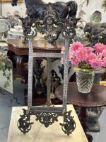 Antique Renaissance Revival metal display easel featuring a finely detailed classical goddess maskeron cresting flanked by twin heraldic griffins on an engraved scrolling frame.