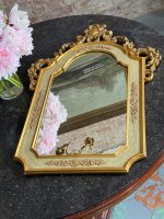 Elegant gilt neo-rococo wall mirror featuring a wooden frame with floral scrolls and a pastel green craquelure finish.