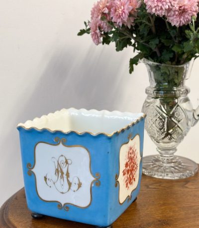 Porcelænskrukke med guldbogstav "M" og røde blomster