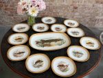 Beautiful limited edition limoges porcelain fish service including a large platter and ten plates with hand-painted fish motifs and heavy gold rims in Naturalism style.
