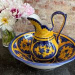 Bright yellow and blue hand-painted ceramic majolica pitcher and basin set with floral motifs in Majolica style.