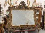 Heavy rococo wall mirror in dark gold with elaborate acanthus and shell motifs
