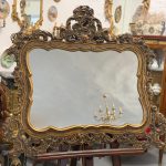 Heavy rococo wall mirror in dark gold with elaborate acanthus and shell motifs