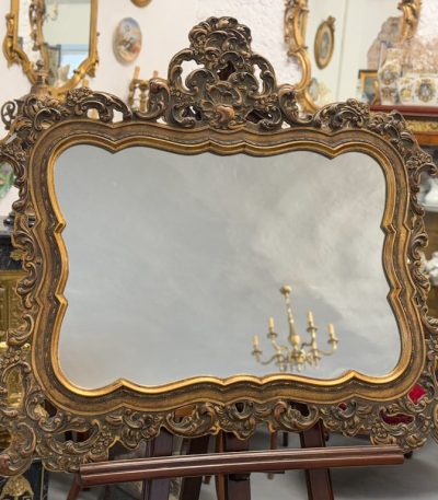 Heavy rococo wall mirror in dark gold with elaborate acanthus and shell motifs