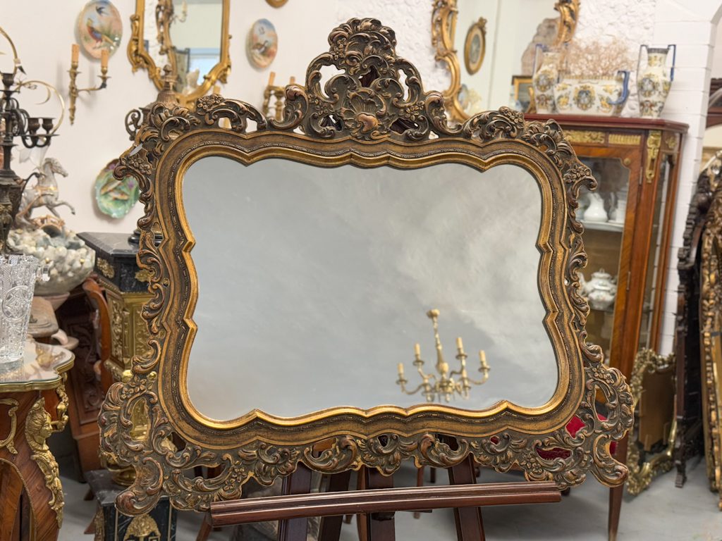 Heavy rococo wall mirror in dark gold with elaborate acanthus and shell motifs