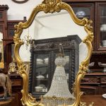 Vintage gold rococo mirror in Louis XV style with flowing acanthus leaves and shell crest