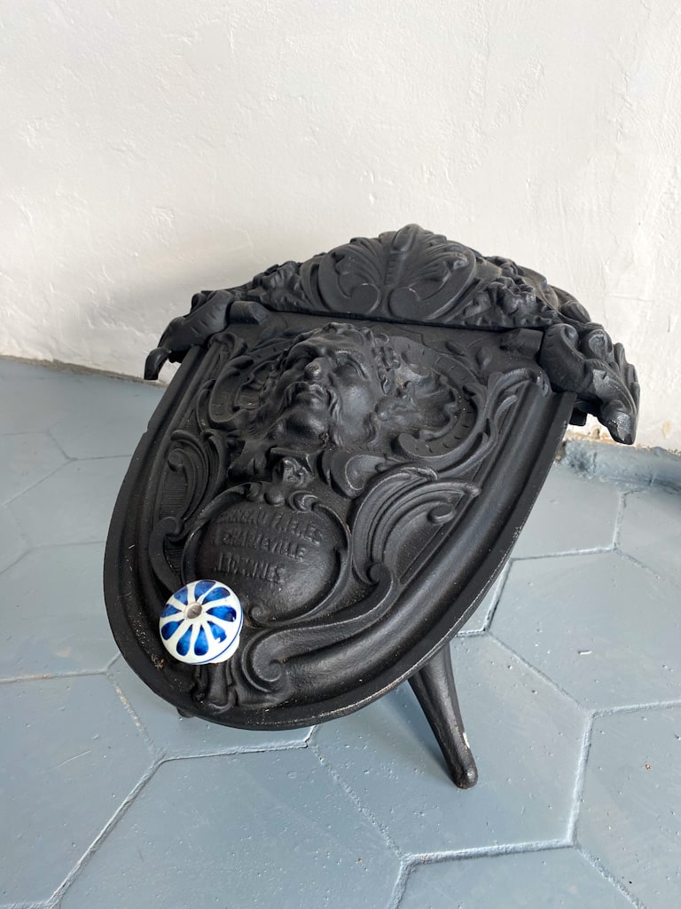 Antique cast iron coalbox by Corneau Frères with bearded mascaron and hinged lid