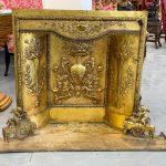 Antique gilt fireplace set with cherub firedogs and repoussé brass relief panels