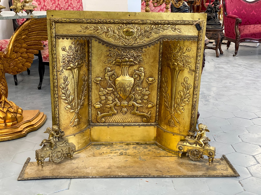 Antique gilt fireplace set with cherub firedogs and repoussé brass relief panels