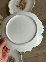 Trīs porcelāna deserta šķīvīši ar putti eņģeļu ainām, reljefu arabesku apmali un zelta malu — Neobaroks / Historicisms, Vācija vai Bohēmija, ap 1880.–1900. gads, 3 gab. (5557) - Image 5