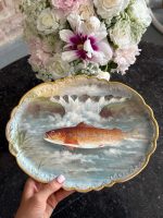 "Limoge" porcelāna šķīvis, apgleznots ar zivs motīvu un zelta krāsas detalizāciju, neliela izmēra (6950)