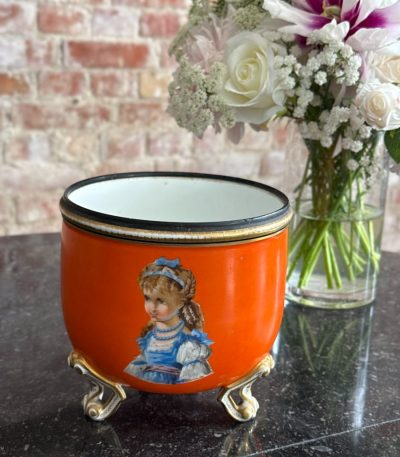 orange porcelain planter in Biedermeier and Neo-Rococo style featuring hand painted children portraits on gilded feet`