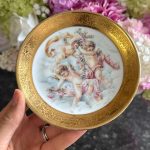 miniatūrs “Limoge” porcelāna šķīvis, apgleznots, ar eņģeļu motīvu un greznu zelta krāsas detalizāciju (7206)