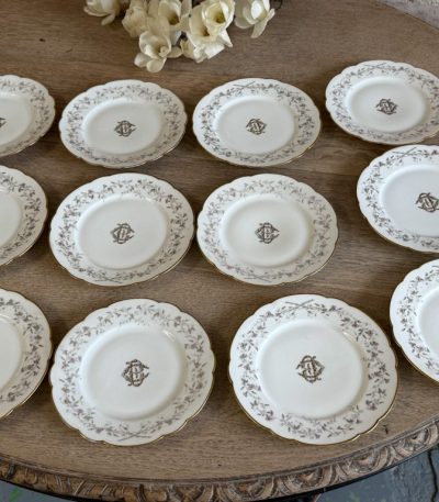 Divpadsmit Limoges porcelāna salātu / kūkas šķīvju komplekts ar CB monogrammu un