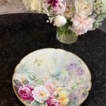 "Limoge" porcelāna šķīvis ar ziedu motīvu, šķīvim ir neliela matveida plaisa (6908)