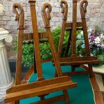 Pair of antique French Empire style carved wood tabletop easels featuring detailed swan neck finials and adjustable brass hardware support brackets.