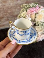 Antique French porcelain tea cup and saucer with hand-painted blue ribbons and floral wreaths