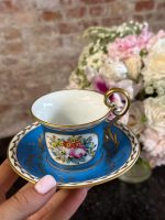 Antique porcelain tea cup and saucer with blue glaze and hand-painted flowers