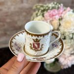 Antique French porcelain espresso cup and saucer with white relief slip barbotine and coat of arms