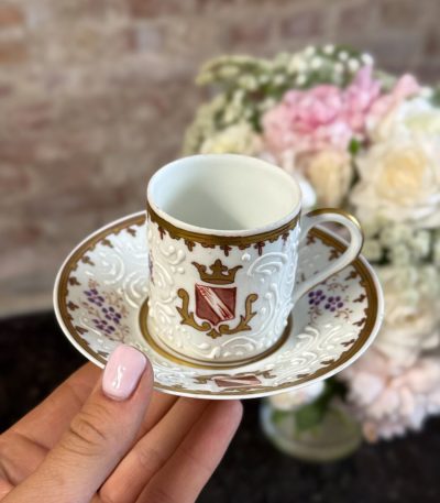 Antique French porcelain espresso cup and saucer with white relief slip barbotine and coat of arms