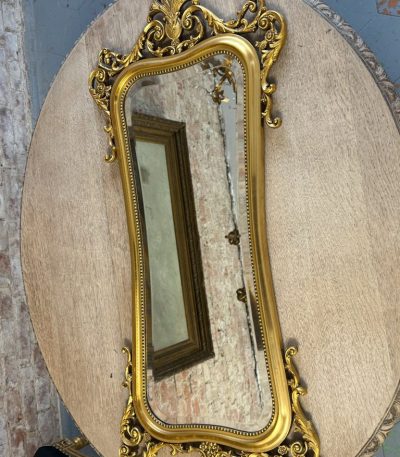 Ornate gilt rococo wall mirror in Louis XV style with floral motifs