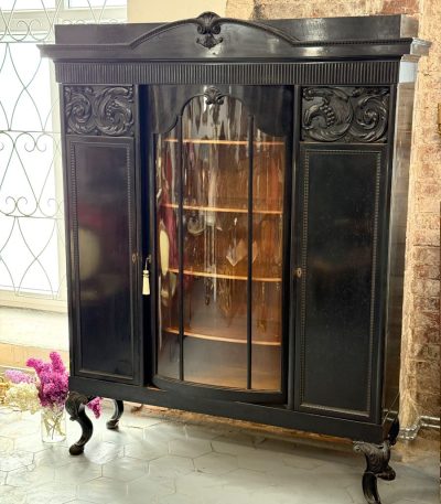 Large black wooden vitrine cabinet with curved glass