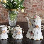 Antique French porcelain tea set with floral motifs and gold trim`