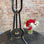 Tall antique black wooden pedestal stand with ornate gilded bronze cherub mounts and floral details in Napoleon III style.