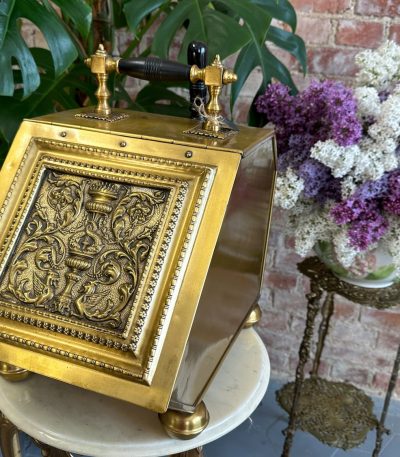 Antique brass coal scuttle with repoussé griffin panel and shovel