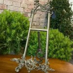 Antique French Rococo style heavy brass tabletop easel featuring ornate scrolling openwork cresting and a deeply detailed asymmetrical rocaille base.